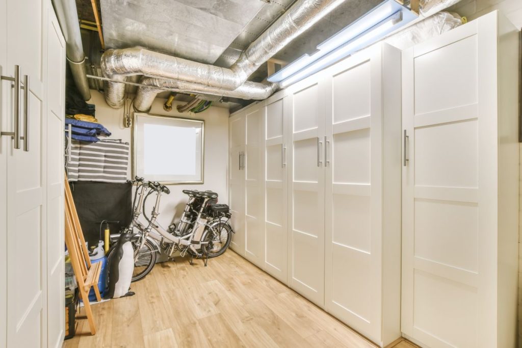 Mehrwert fürs Untergeschoss 1 Kellerraum mit einem großen weißen Wandschrank und Fahrrädern.