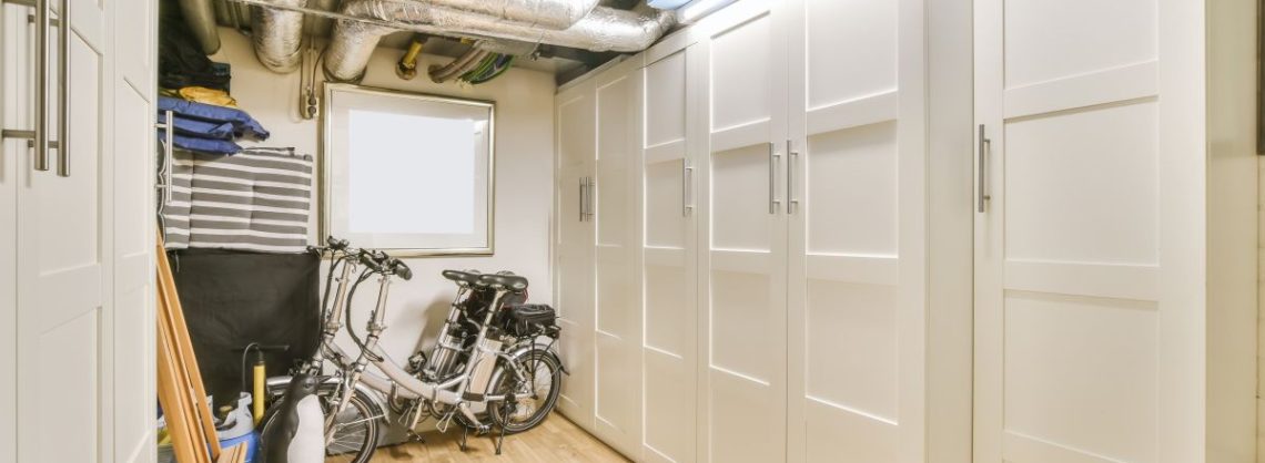Kellerraum mit einem großen weißen Wandschrank und Fahrrädern.