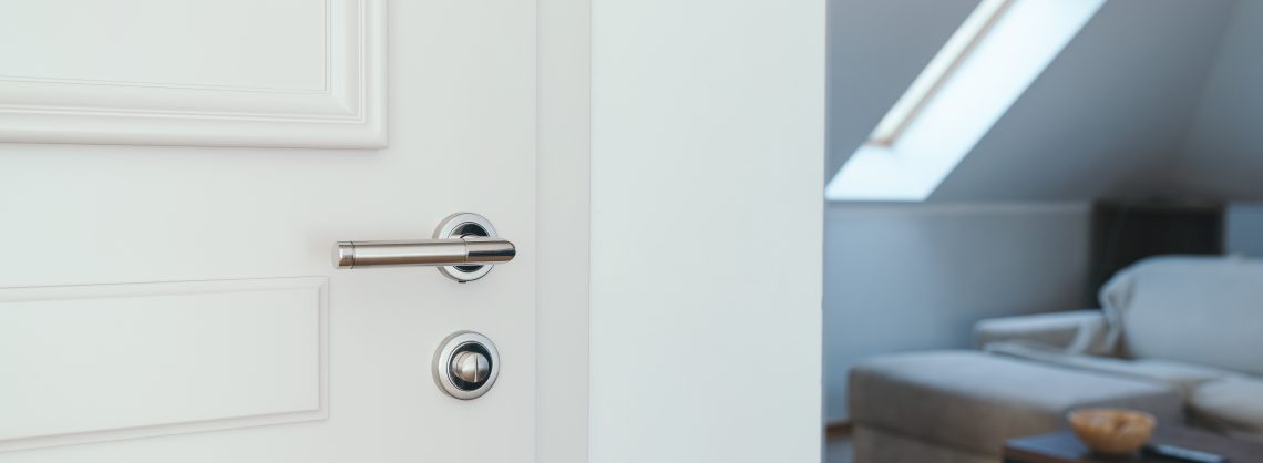 Tür der Hotelwohnung, weiße Holztür mit Metallgriff, selektiver Fokus