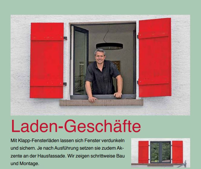 Auf dem Bild ist schaut ein dunkelhaariger Mann aus einem Fenster, an dem rote Holz-Fensterläden angebracht sind.