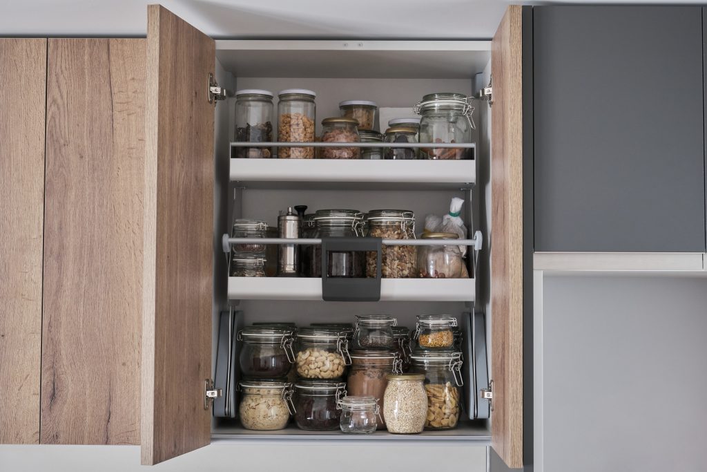 So lässt sich Ordnung halten 1 Verschiedene trockene Lebensmittel, Getreide, Nüsse, Müsli in Gläsern im Küchenschrank. Zero-Waste-Lagerkonzept.