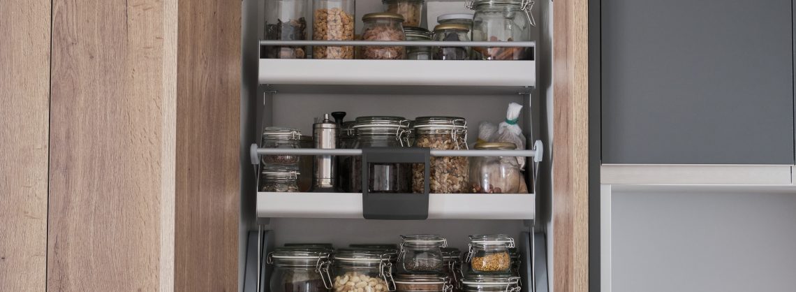 Verschiedene trockene Lebensmittel, Getreide, Nüsse, Müsli in Gläsern im Küchenschrank. Zero-Waste-Lagerkonzept.