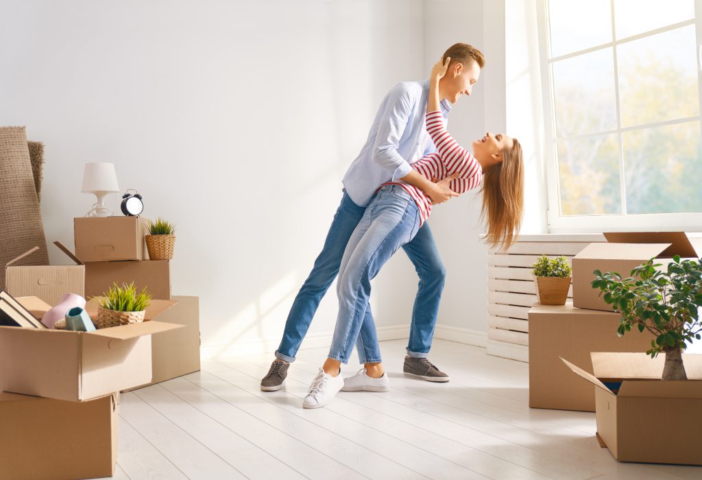 Glückliches junges Ehepaar zieht in eine neue Wohnung.