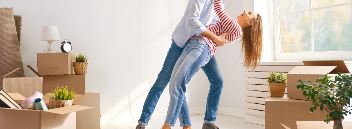 Glückliches junges Ehepaar zieht in eine neue Wohnung.