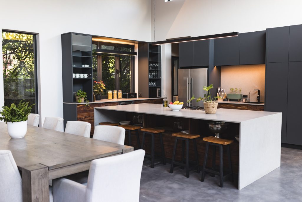 Wenn die Küche in die Jahre kommt – Verjüngungskur gefällig? 1 Moderne Küche mit großer Kochinsel, Barhockern und Esstisch in einem modernen Zuhause. Inneneinrichtung, Design, Luxus, Stil, Architektur, Dekor