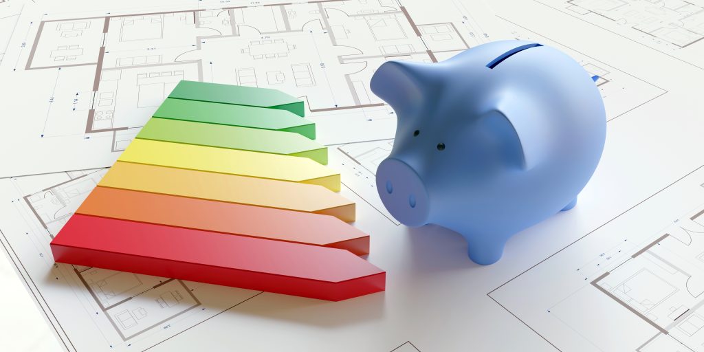 Energieeffizienz lässt sich messen 1 Energieeffizienzklassen auf einem weißen Plan, daneben steht ein Sparschwein.