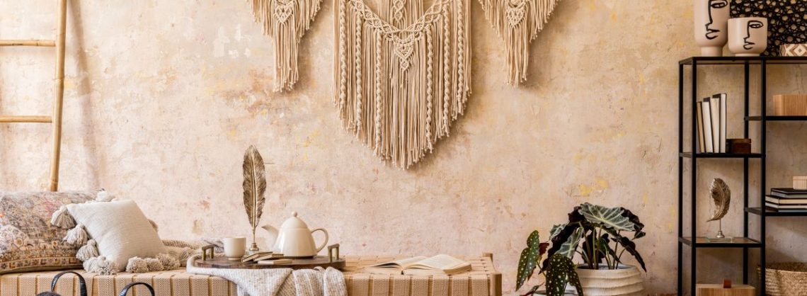 Innenarchitektur des stilvollen Wohnzimmers mit Chaiselongue, schöner Makramee, Rattan-Dekoration, Pflanzen, Buch, Pflanze, eleganten persönlichen Accessoires im orientalischen Konzept der Wohnkultur.