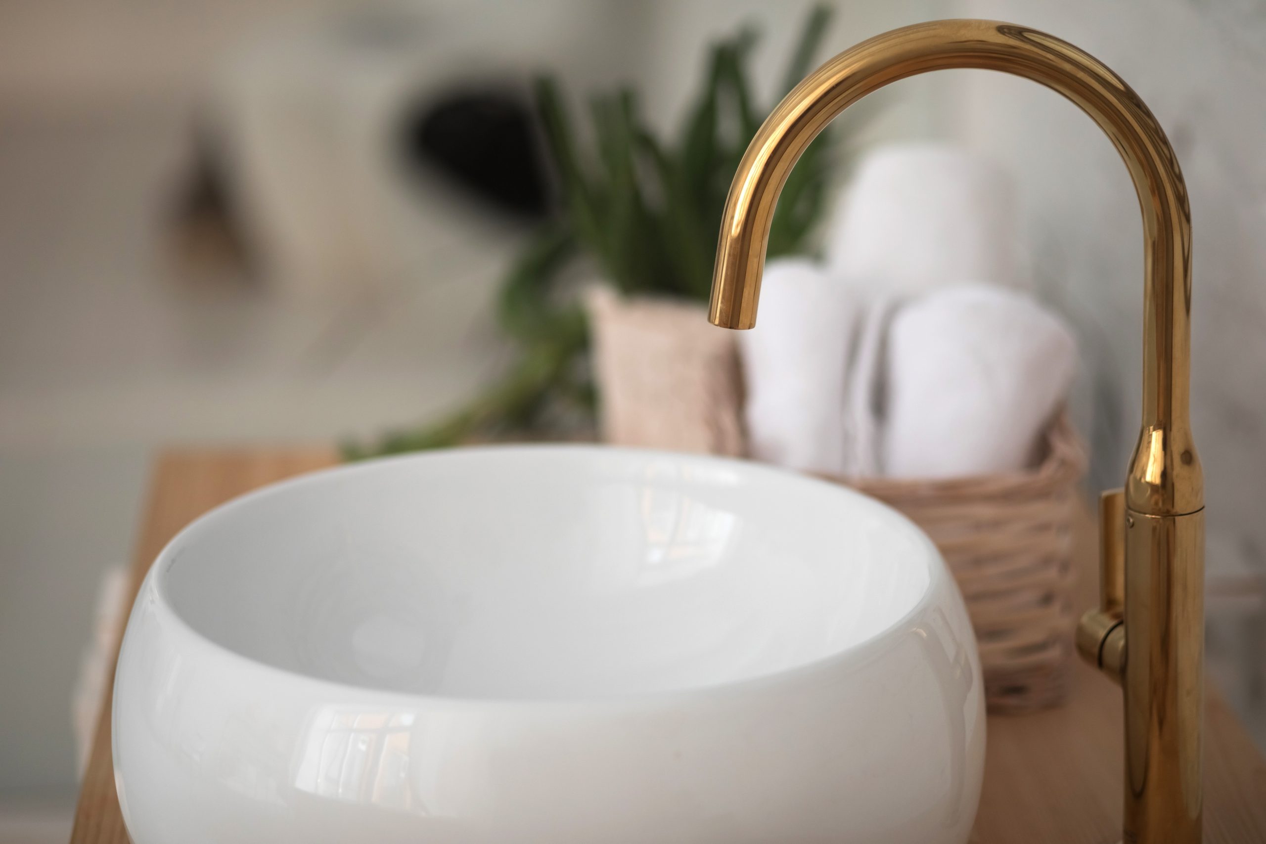 Sanitär: Weißes Waschbecken und goldene Armatur