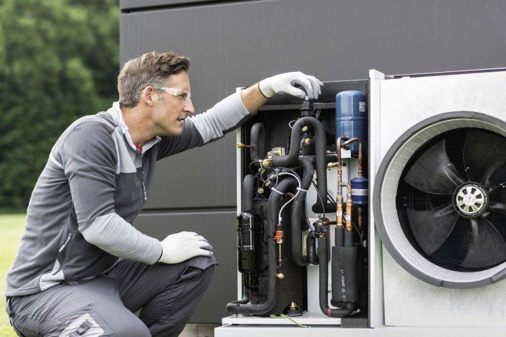 Altbau heizen Handwerker bei der Installation einer Wärmepumpe