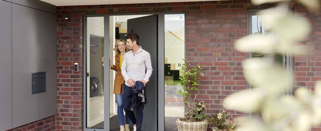 Ein Paar verlässt ihr Haus das mit Smarthome Funktionen gesichert ist.