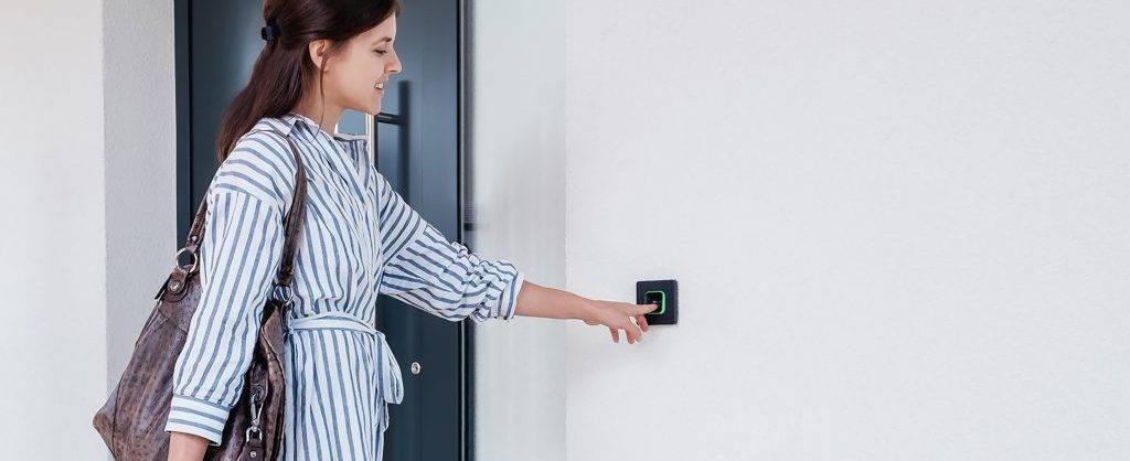 Frau nutzt Fingerprint Funktion bei der smartkey Zutrittskontrolle.