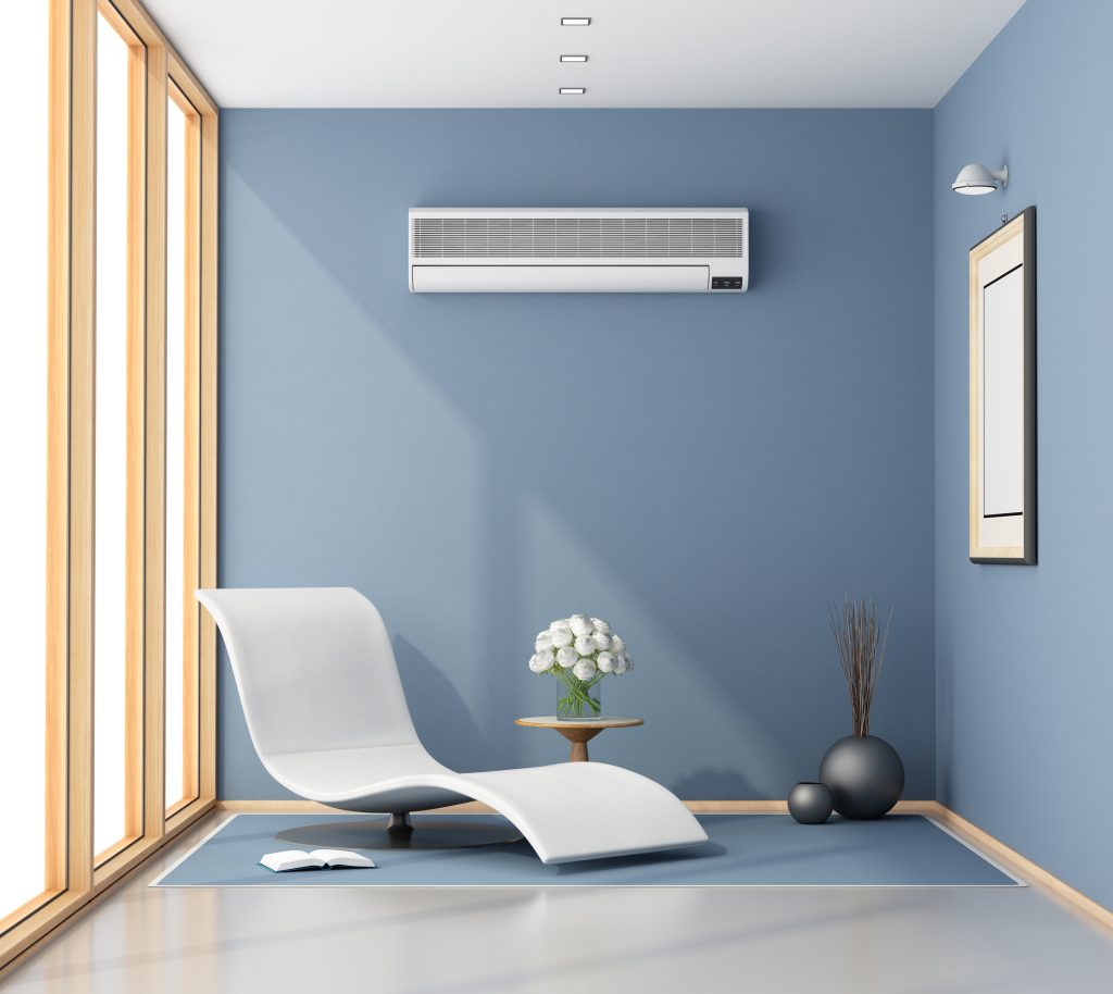 Raum mit blauen Wänden und einer großen Fensterfront und Sitzmöbeln. An der Wand befindet sich eine Klimaanlage.