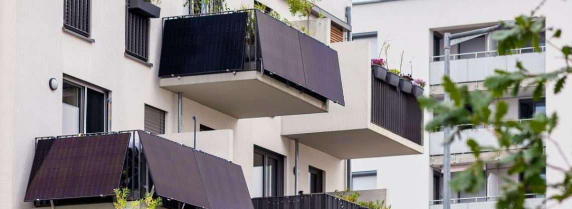 Mehrere Balkone eines Mehrfamilienhauses mit Solar Panelen.