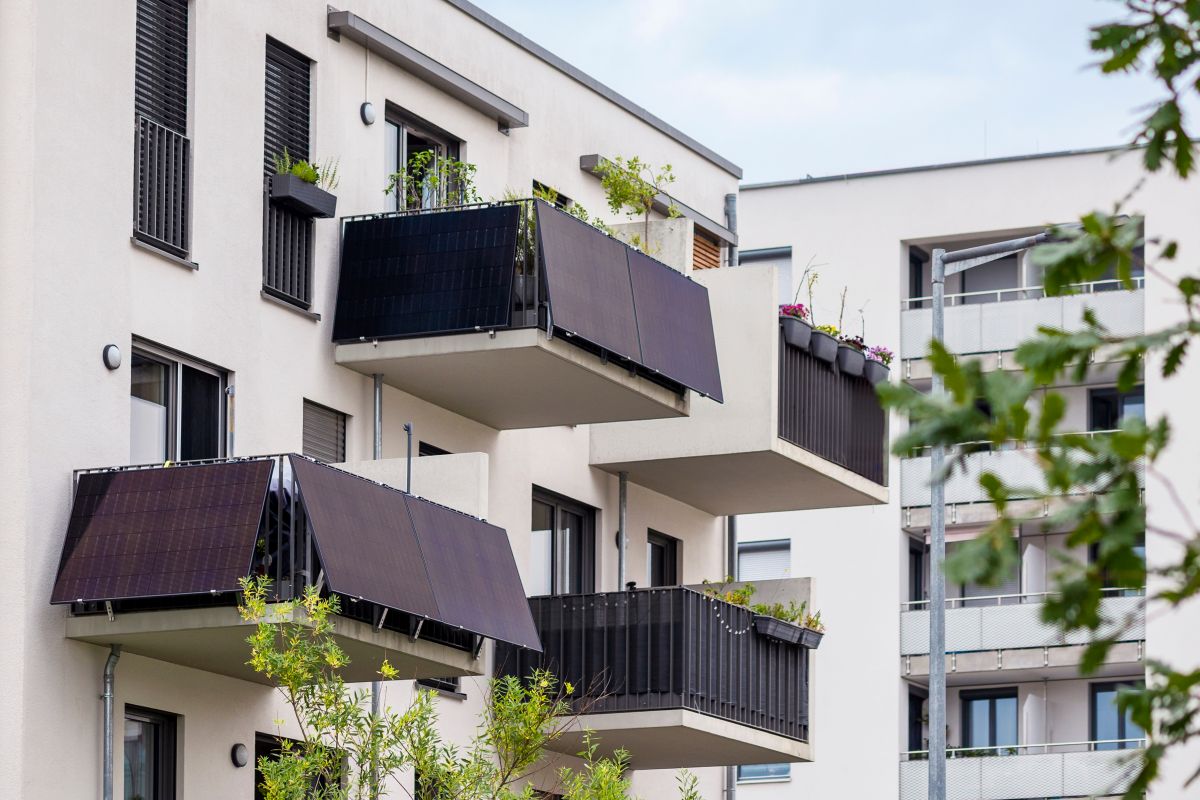 Mehrere Balkone eines Mehrfamilienhauses mit Solar Panelen.