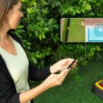 Stiga Frau steuert Rasenroboter per Handy