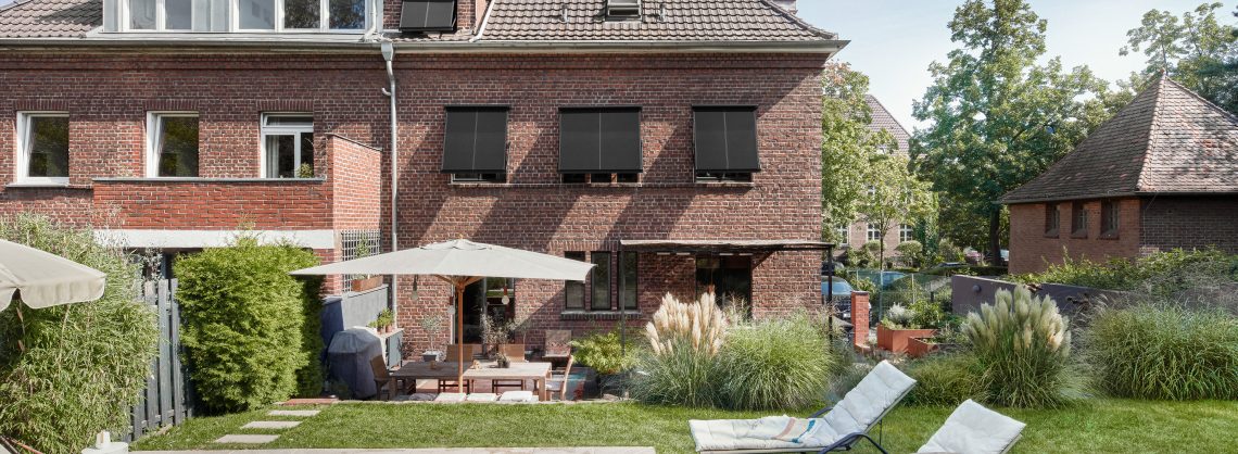 Warema Sonnenschutz Markise. Ein Einfamilienhaus mit Sonnenschutz. Davor ein Garten mit Pool und Liegen dabei.