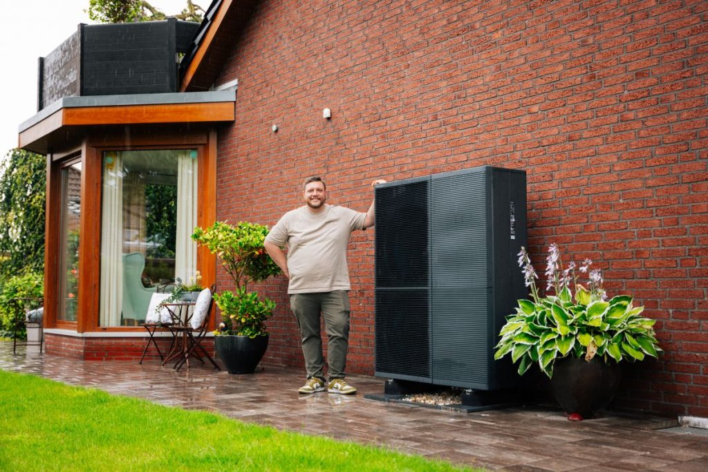 Panasonic Bauherr mit Wärmepumpe vor dem Haus
