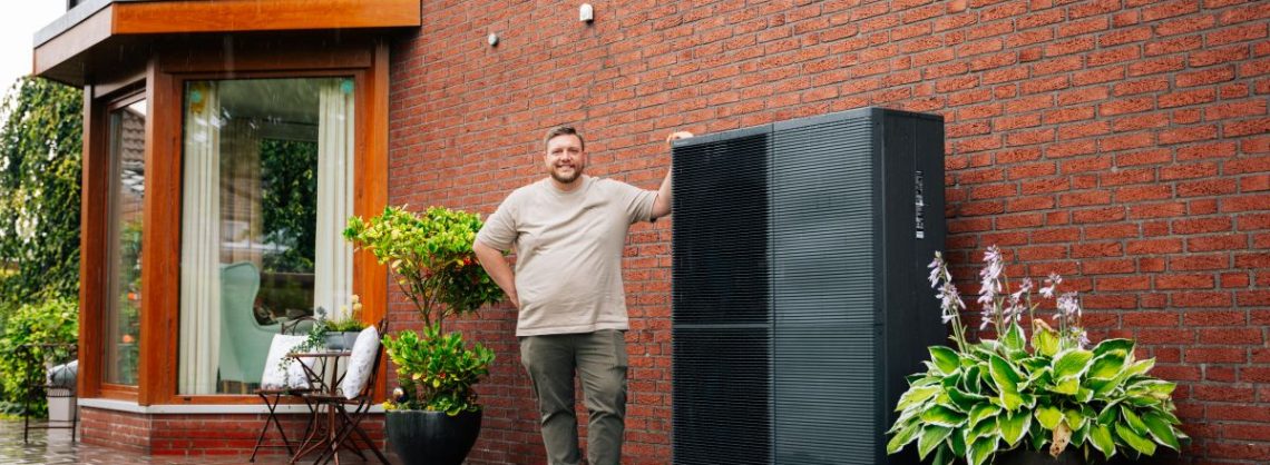 Panasonic Bauherr mit Wärmepumpe vor dem Haus