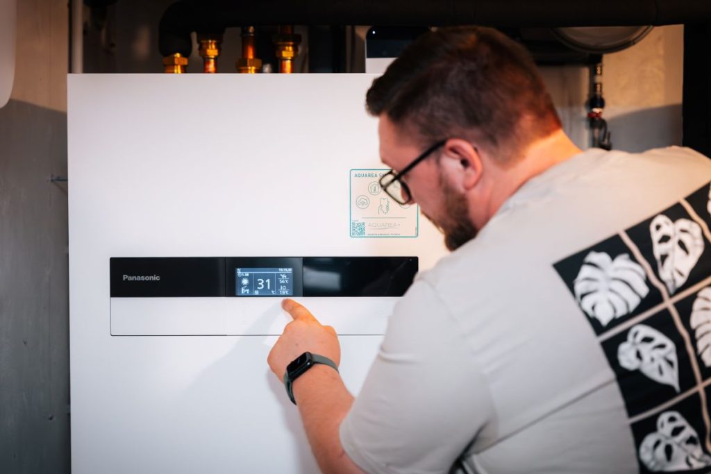 Bauherr überprüft Digitalanzeige Wärmepumpe